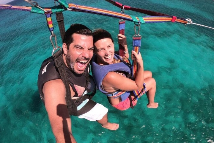 Couple is parasailing.