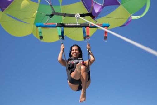 a person flying through the air while holding a kite